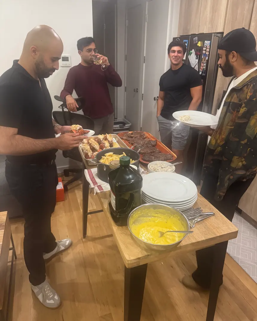 Friends serving dinner together around a kitchen table